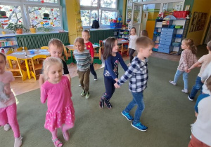 Dzieci w rytmie piosenki "Zuzanna" poruszają się w parach po sali, tworząc "saneczki"