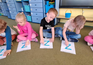 Olaf, Nadia, Tymek, Stasio i Marysia kreślą palcami litery "Z" na wyklejonych wzorach do piosenki "Zuzanna"