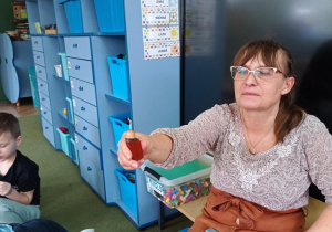 Nauczycielka pokazuje dzieciom przyciąganie się dwóch magnesów