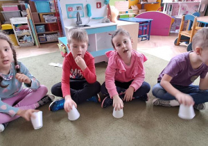 Dzieci wygrywają rytm piosenki "Ula", stukając kubeczkami o podłogę