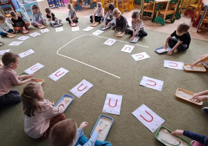 Dzieci "rysują" palcami litery "U" na mannie w rytmie piosenki "Ula"