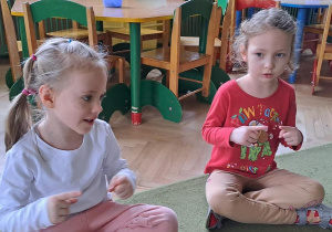 Lena i Laura uczestniczą w zabawie paluszkowej z rymowanką „Cmok-cmok paluszków”