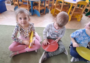 Klara i Filipy wygrywają rytm piosenki "Celina" na talerzykach do ćwiczeń