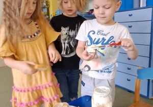 Klara, Gabrysia i Filip przygotowują bagietki z masłem
