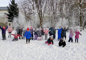 dzieci rzucają śniegiem wysoko do góry