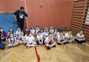 Dzieci zebrały się na sali gimnastycznej i czekają na zawody.