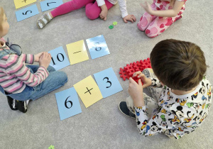 starszaki rozwiązują równania matematyczne na dywanie