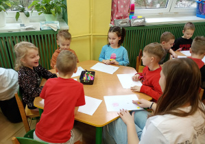 Dzieci wymieniają się kartkami z rysunkami