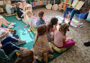 Dzieci oglądają obrazki ilustrujące opowieść "O Wilku, który wypadł z książki"