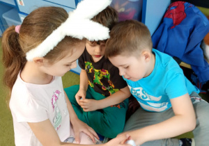 Dziewczynka częstuje rówieśników wielkanocnymi słodkościami