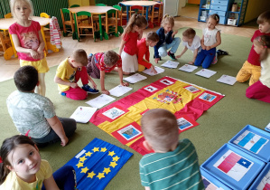 Dzieci wybierają kolorowanki z flagami państw, w których można porozumieć się w języku hiszpańskim