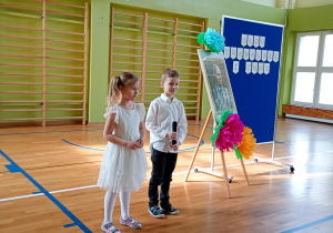 Chłopiec i dziewczynka recytują wiersz Juliana Tuwima pt. "Skakanka"