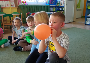 Chłopiec nadmuchuje balon
