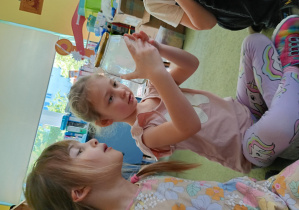 Dziewczynki obserwują smog, który powstał w słoiku podczas zabawy badawczej