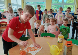 Paweł wkłada marchewkę do słoika