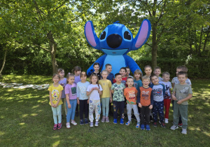 Grupowe zdjęcie Misiów z dużą maskotką Stitcha.