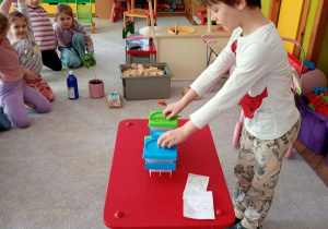 Chłopiec waży przedmioty i sprawdza, czy dzieci dobrze odgadły zagadkę (j.w.)