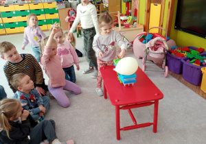 Dziewczynka waży i porównuje wagę - balon i nakrętka