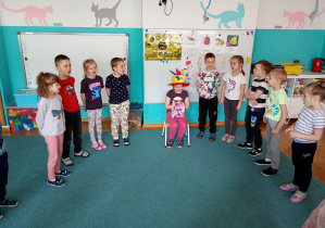Dzieci stoją w kole, skłądają Dobrusi życzenia urodzinowe