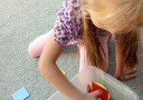 Marysia bawi się plastikowymi figurami geometrycznymi