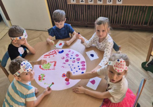 dzieci wspólnie tworzą obraz z kropek robionych farbami