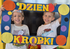 chłopcy pozują do zdjęcia w ramce z kropek