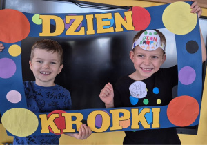 chłopcy pozują do zdjęcia w ramce z kropek