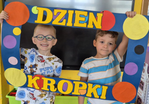 chłopcy pozują do zdjęcia w ramce z kropek