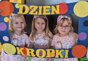 dziewczynki pozują do zdjęcia w ramce z kropek