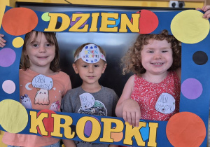 dziewczynki pozują do zdjęcia w ramce z kropek