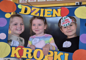 dwóch chłopców i dziewczynka pozują do zdjęcia