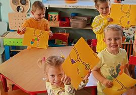 Dzieci ozdabiają magiczne okulary przy czerwonym stoliku