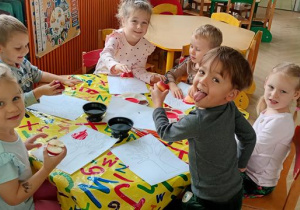 Dzieci ozdabiają drzewa stemplami z jabłek