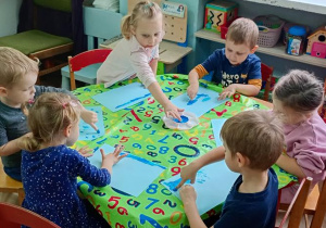 Dzieci malują muzykę, którą słyszą na niebiesko
