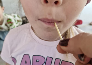 Dziecko zgaduje jaki to owoc lub warzywo za pomocą zmysłu smaku