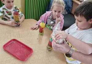 Dzieci wsypują produkty żywnościowe do butelek