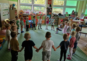 Dzieci stoją w kole i śpiewają sto lat dla Veroniki