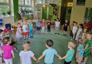 Dzieci stoją w kole i śpiewają sto lat dla Veroniki
