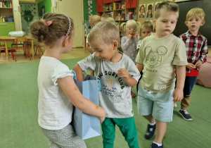 Oliwka częstuje dzieci cukierkami