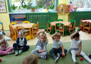 Dzieci podnoszą zielone piłeczki