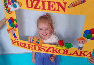 Telimena w żółtej ramce z napisem Dzień Przedszkolaka – pamiątkowe zdjęcie z radosnego święta