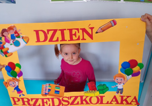 Ala w żółtej ramce z napisem Dzień Przedszkolaka – pamiątkowe zdjęcie z radosnego święta
