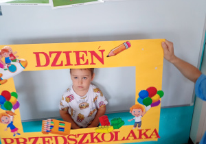 Ignacy w żółtej ramce z napisem Dzień Przedszkolaka – pamiątkowe zdjęcie z radosnego święta