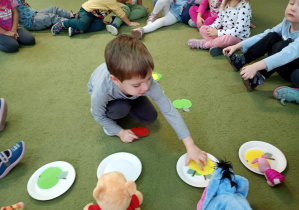 Chłopiec przydziela owocowe sylwety pluszowemu Kłapouchemu