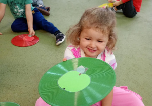 Dziewczynka położyła sywetę zielonego jabłka na zielonym krążku