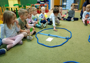 Dziewczynka przydziela do koszyka ze schematem śliwki właściwy owoc