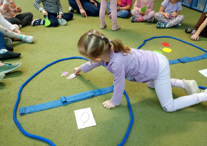 Dziewczynka przydziela do koszyka ze schematem śliwki właściwy owoc