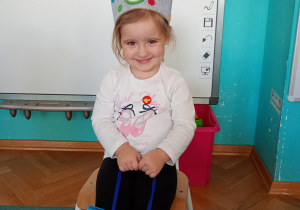 Nasza solenizantka Lila, siedzi na krześle, w koronie z cyfrą 3.