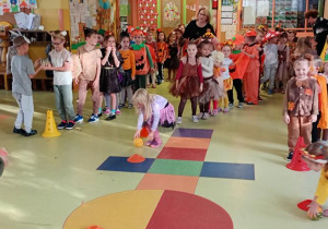 Dzieci toczą dynie do celu.