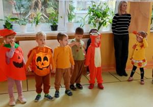 Dzieci tańczą i śpiewają w kole.